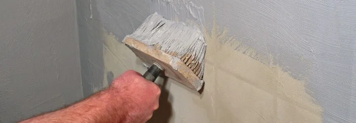 Person trägt Dichtmasse mit Quast auf